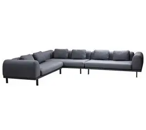 L-formet sofa i gråt stof med mørke ben, består af flere polstrede sektioner.